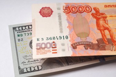 Beş bin rublelik Rus banknotu 100 dolarlık Amerikan banknotunun üzerinde asılı duruyor. Close