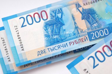 İki bin rublelik Rus banknotları beyaz bir kâğıt arka planın üzerinde asılı duruyor. Banknotlar Vostochny uzay merkezini ve Soyuz roketini gösteriyor. Yukarıdan görüntüleyin. Close