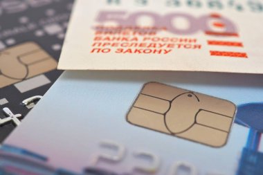 Banka kartları ve 5000 rublelik banknot parçası. Ödeme sistemi Mir. Close