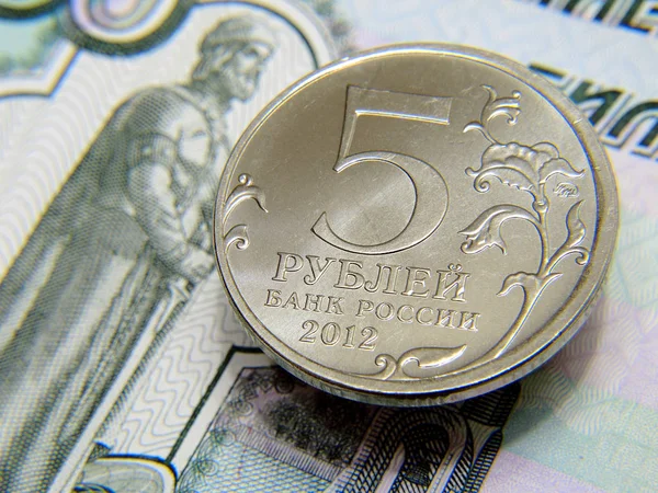 5 rublelik bir Rus sikkesi 1000 rublelik banknotta yatıyor. Bireylere, ticari bankalara, mikrofinans şirketlerine ve mikrokredi şirketlerine borç verme haberleri. Yakın plan.