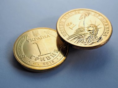 1 Hryvnia 'da Ukrayna parası ve 1 Amerikan doları. Yakın plan. Mavi ya da gri bir arka planda dur. Para birimlerinin döviz kuru teması üzerine parlak bir illüstrasyon. Makro