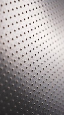 Birçok deliği olan delinmiş alüminyum yüzey. Safları uzaklaşıyor ve bir perspektif oluşturuyor. Cep telefonu için koyu dikey duvar kağıdı. Endüstriyel gri metal arka plan. Makro