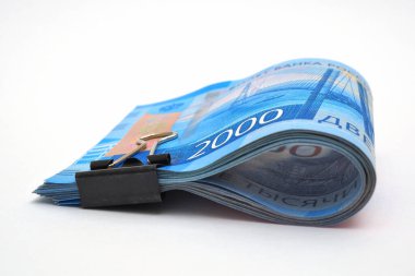 2000 ruble 'lik bir deste Rus parası. Para ofis şarjörüyle bağlanmış ve beyaz bir arka planda yatıyor. İzole değil. Rusya 'da çocuk nafakası ve işsizlik yardımı. Makro