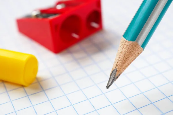 Kalem, kalem açacağı ve keçeli kalem yakın plan kare defter kağıdı. Yeni okul yılının başlangıcı için bir resim. 1 Eylül. Makro