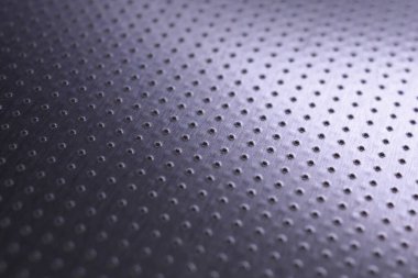 Renkli menekşe ya da mor metal teknolojisi. Siyah duvar kağıdı. Birçok deliği olan delinmiş alüminyum yüzey. Safları uzaklaşıyor ve bir perspektif oluşturuyor. Makro