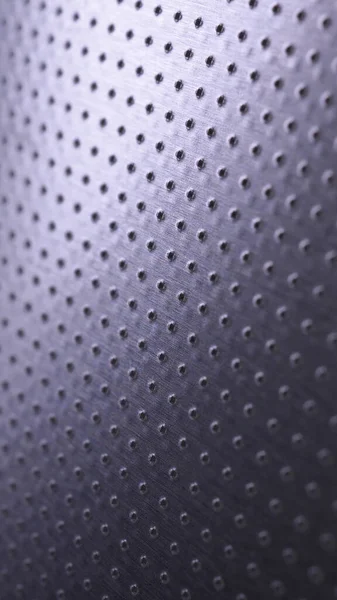 Dark metallic mobile wallpaper. Perforated aluminum surface with many holes. Tinted violet or purple tech background. Vertical metal backdrop. Macro