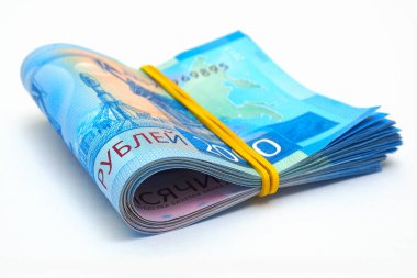 Yuvarlanmış Rus 2000 'i. İki bin ruble banknot. Beyaz bir kağıt yüzeyde yatıyor. Banknotlar elastik bant ile sıkılaştırılmış. Banka kredileri, mevduatlar ve faizler