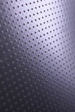 Renkli menekşe ya da mor metalik arka plan. Karanlık dikey duvar kâğıdı. Birçok deliği olan delinmiş alüminyum yüzey. Makro