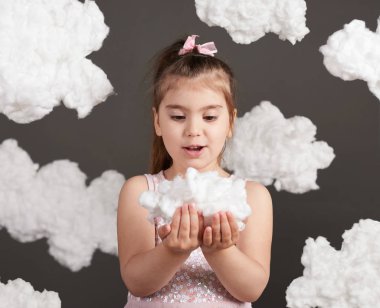 bir bulut gri bir arka plan üzerinde stüdyoda çekim onun elinde tutan kız