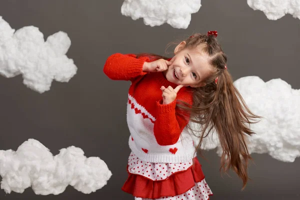 遊んで雲 赤いセーターを着た女の子が灰色の背景にスタジオで撮影 — ストック写真