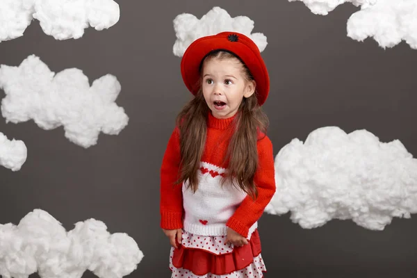Девушка Играет Облаками Одета Красный Свитер Снята Студии Сером Фоне — стоковое фото