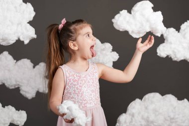 bulutlar ve çalış, gri bir arka plan üzerinde stüdyoda çekim kız dokunur