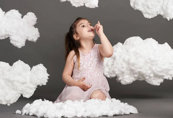 girl playing with clouds, shot in the studio on a gray background