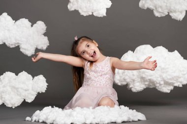 bulutlar, gri bir arka plan üzerinde stüdyoda çekim ile oynayan kız