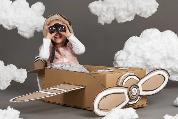 Παιδί Κορίτσι Παίζει Ένα Αεροπλάνο Από Χαρτόκουτο Και Ονειρεύεται Γίνει — Φωτογραφία Αρχείου