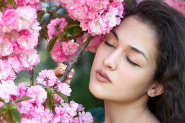 güzel kız poz yakınındaki pembe sakura çiçekler gibi arka plan, yüz portre, manzara bahar