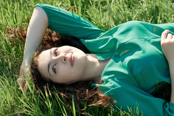 güzel kız çimlere güneşli gün, yüz closeup, yaz orman, parlak manzara gölgeler ile yalan