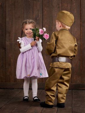Çocuk Çocuk giyinmiş retro askeri üniformalı asker ve pembe elbiseli kız olarak