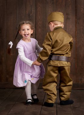 Çocuk Çocuk giyinmiş retro askeri üniformalı asker ve pembe elbiseli kız olarak