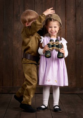 Çocuk Çocuk giyinmiş retro askeri üniformalı asker ve pembe elbiseli kız olarak