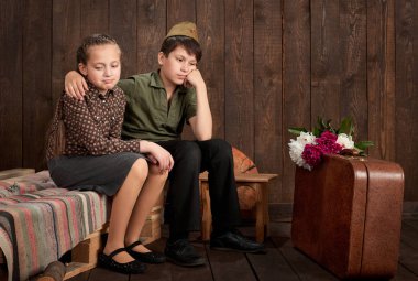 Çocuk retro askeri üniformalı bir asker gönderme ordu, koyu ahşap arka plan, retro tarzı giyinmiş