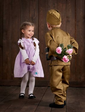 Çocuk Çocuk giyinmiş retro askeri üniformalı asker ve pembe elbiseli kız olarak