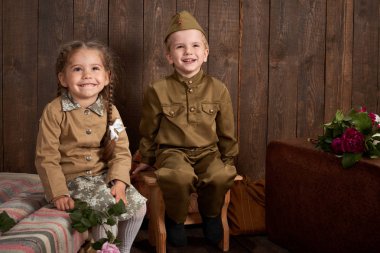 Çocuk retro askeri üniformalı bir asker gönderme ordu, koyu ahşap arka plan, retro tarzı giyinmiş