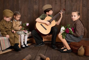 Çocuk bir asker gönderme ordu, koyu ahşap arka plan, retro tarzı oturma ve gitar, çalmak retro askeri üniforması giymiş