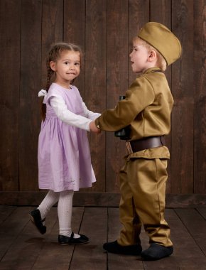 Çocuk Çocuk giyinmiş retro askeri üniformalı asker ve pembe elbiseli kız olarak