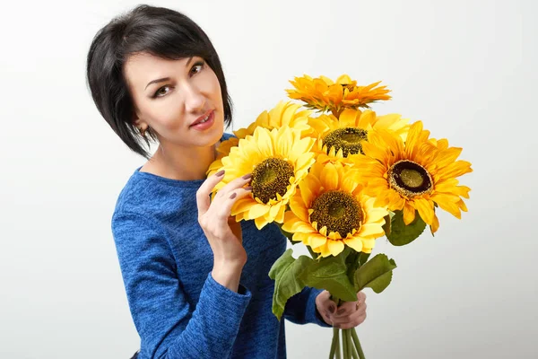 woman with sunflower posing in blue dress