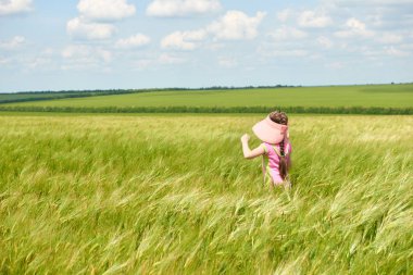 Buğday alan, parlak güneş, güzel yaz manzara ile yürüyüş çocuk