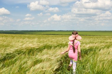 Buğday alan, parlak güneş, güzel yaz manzara ile yürüyüş çocuk