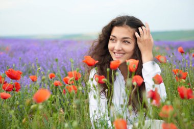 Genç kız lavanta, güzel yaz manzara haşhaş kırmızı çiçekli alanındadır