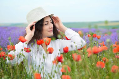 Genç kız lavanta, güzel yaz manzara haşhaş kırmızı çiçekli alanındadır