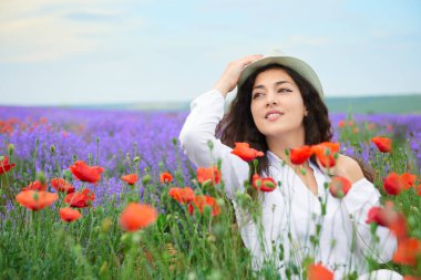 Kırmızı çiçekli haşhaş, güzel yaz manzara lavanta alanında genç kızdır