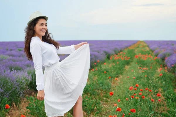 Kırmızı çiçekli haşhaş, güzel yaz manzara lavanta alanında genç kızdır