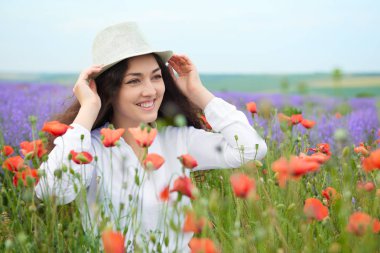 Genç kız lavanta, güzel yaz manzara haşhaş kırmızı çiçekli alanındadır