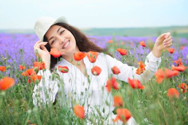 Kırmızı çiçekli haşhaş, güzel yaz manzara lavanta alanında genç kızdır