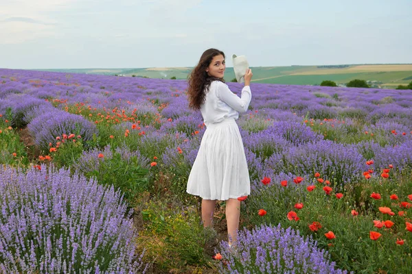 young girl is in the lavender field, beautiful summer landscape with flowers