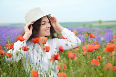 Genç kız lavanta, güzel yaz manzara haşhaş kırmızı çiçekli alanındadır