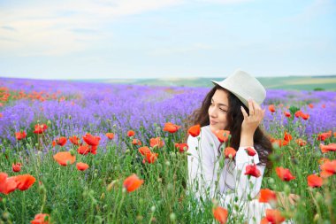 Kırmızı çiçekli haşhaş, güzel yaz manzara lavanta alanında genç kızdır