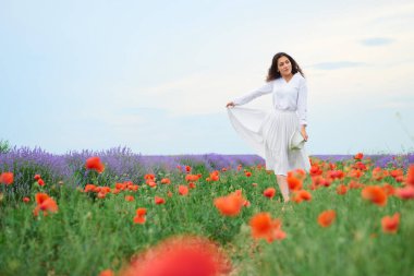 Genç kadın lavanta, güzel yaz manzara haşhaş kırmızı çiçekli alanındadır