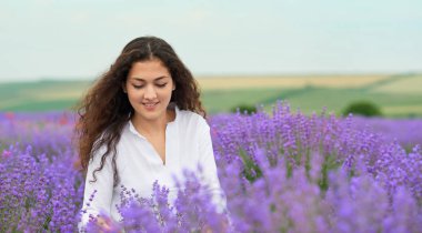 Genç kadın lavanta, güzel yaz manzara haşhaş kırmızı çiçekli alanındadır