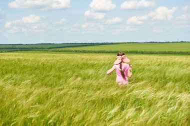 Buğday alan, parlak güneş, güzel yaz manzara ile yürüyüş çocuk