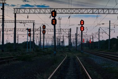 Tren trafik ışıkları ve altyapı güzel gün batımı, renkli gökyüzü, ulaşım ve Sanayi kavramı sırasında