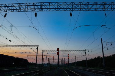 Tren trafik ışıkları ve altyapı güzel gün batımı, renkli gökyüzü, ulaşım ve Sanayi kavramı sırasında