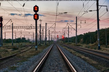 Tren trafik ışıkları ve altyapı güzel gün batımı, renkli gökyüzü, ulaşım ve Sanayi kavramı sırasında