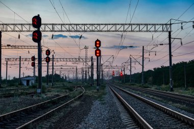 Tren trafik ışıkları ve altyapı güzel gün batımı, renkli gökyüzü, ulaşım ve Sanayi kavramı sırasında