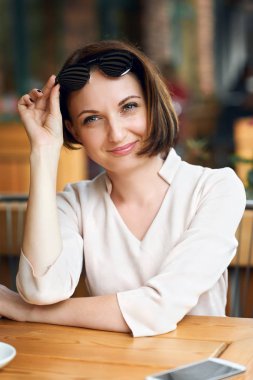 Genç kadın içecekler kahve kafeterya ve güneş gözlüğü ile poz