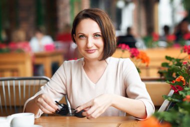 Genç kadın içecekler kahve kafeterya ve güneş gözlüğü ile poz